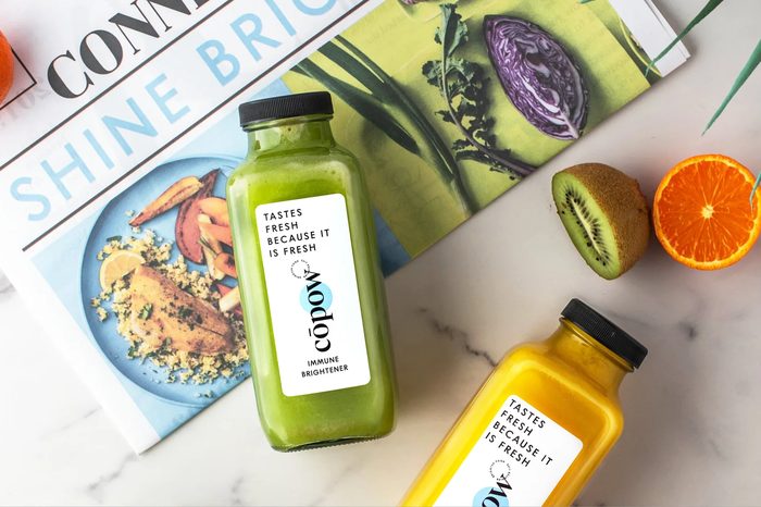 Cōpow Foods cold-pressed juice bottles styled with fresh produce
